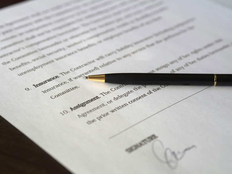 Close-up of a contract with a pen resting on top.